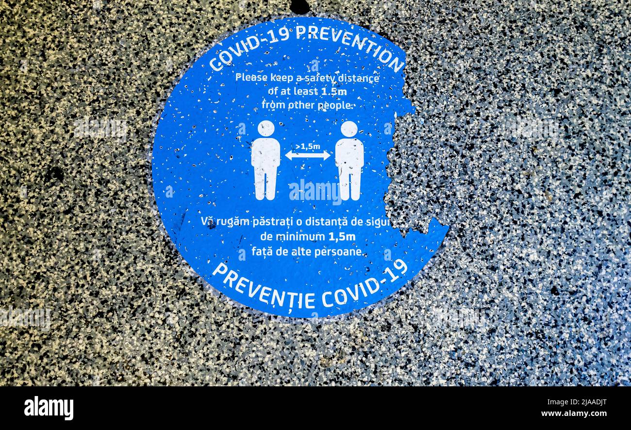 Cartel de piso de prevención Covid-19 de la enfermedad. Mantener dibujo de ilustración de distanciamiento físico. Aeropuerto rumano, OTP, Otopeni, Bucarest Foto de stock