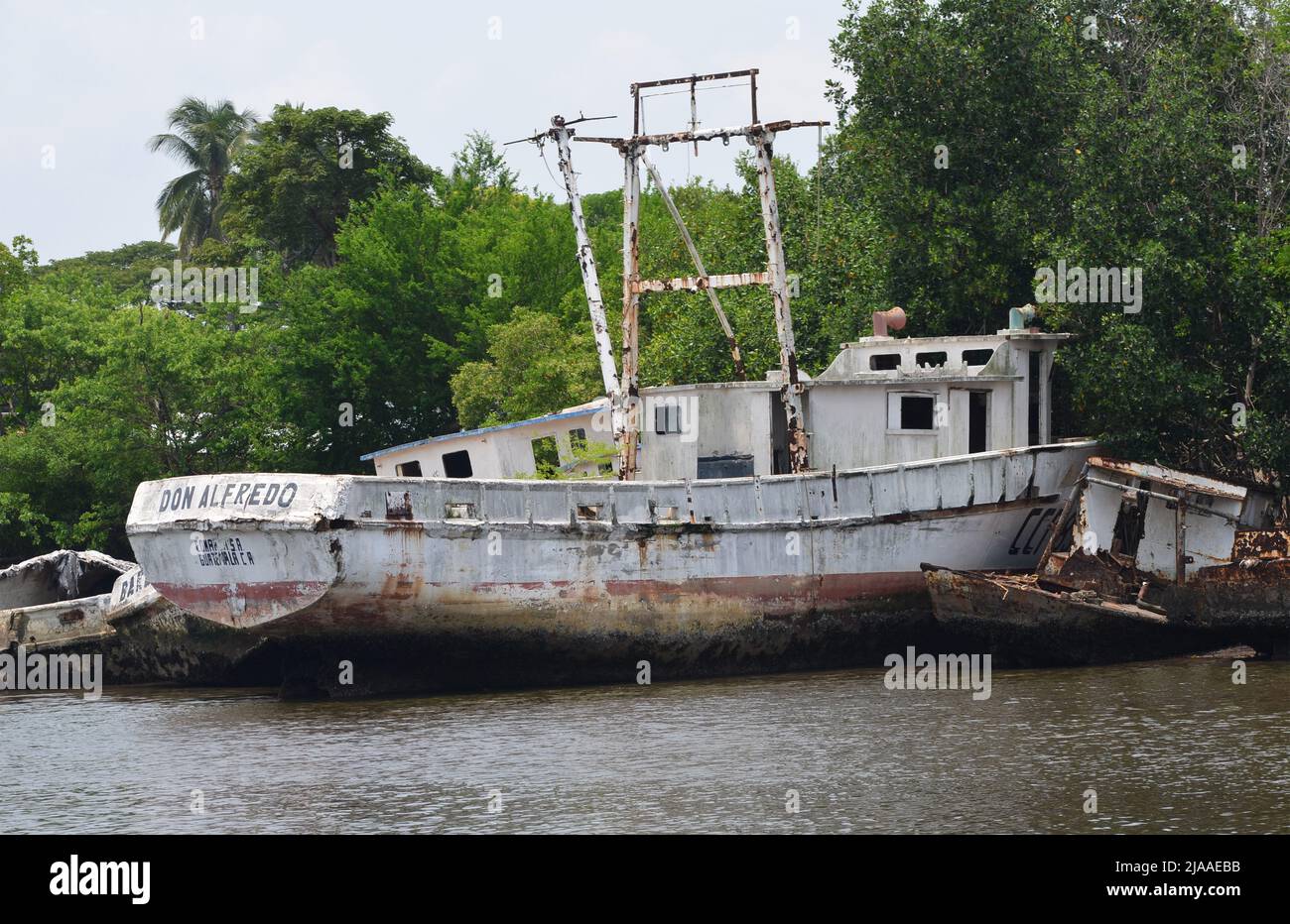 Barcos pesqueros y barcos abandonados en Puerto San José, costa del Pacífico de Guatemala Foto de stock