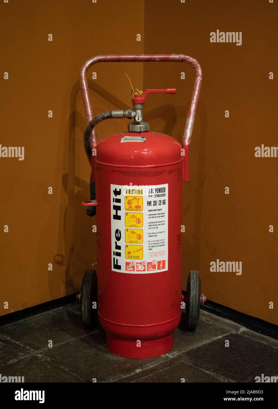 Un extintor de incendios en la esquina de la sala está disponible en caso de emergencia. Foto de stock