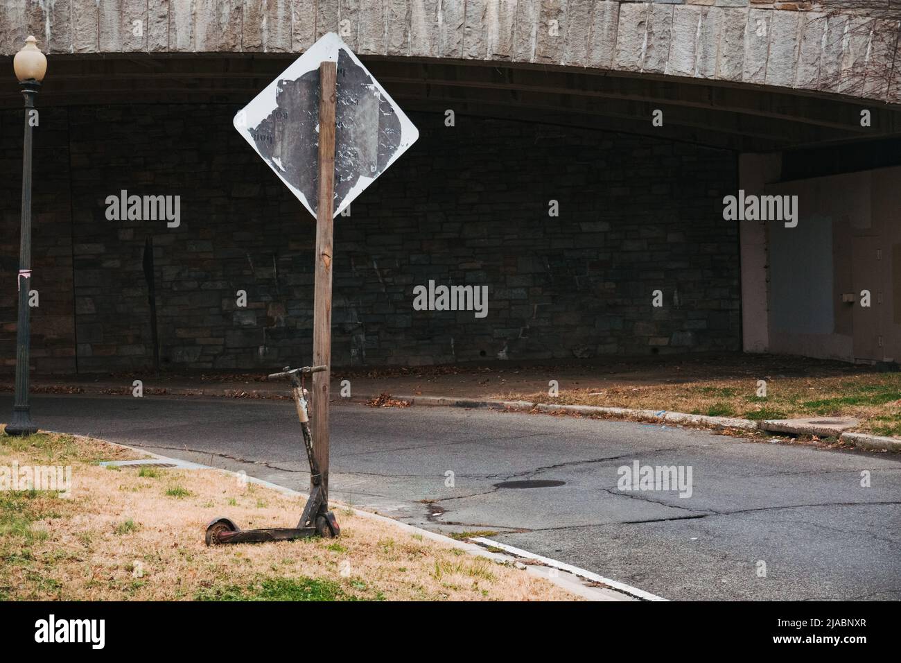 Un e-scooter abandonado compartido al lado de una señal de carretera en Washington, D.C. Foto de stock