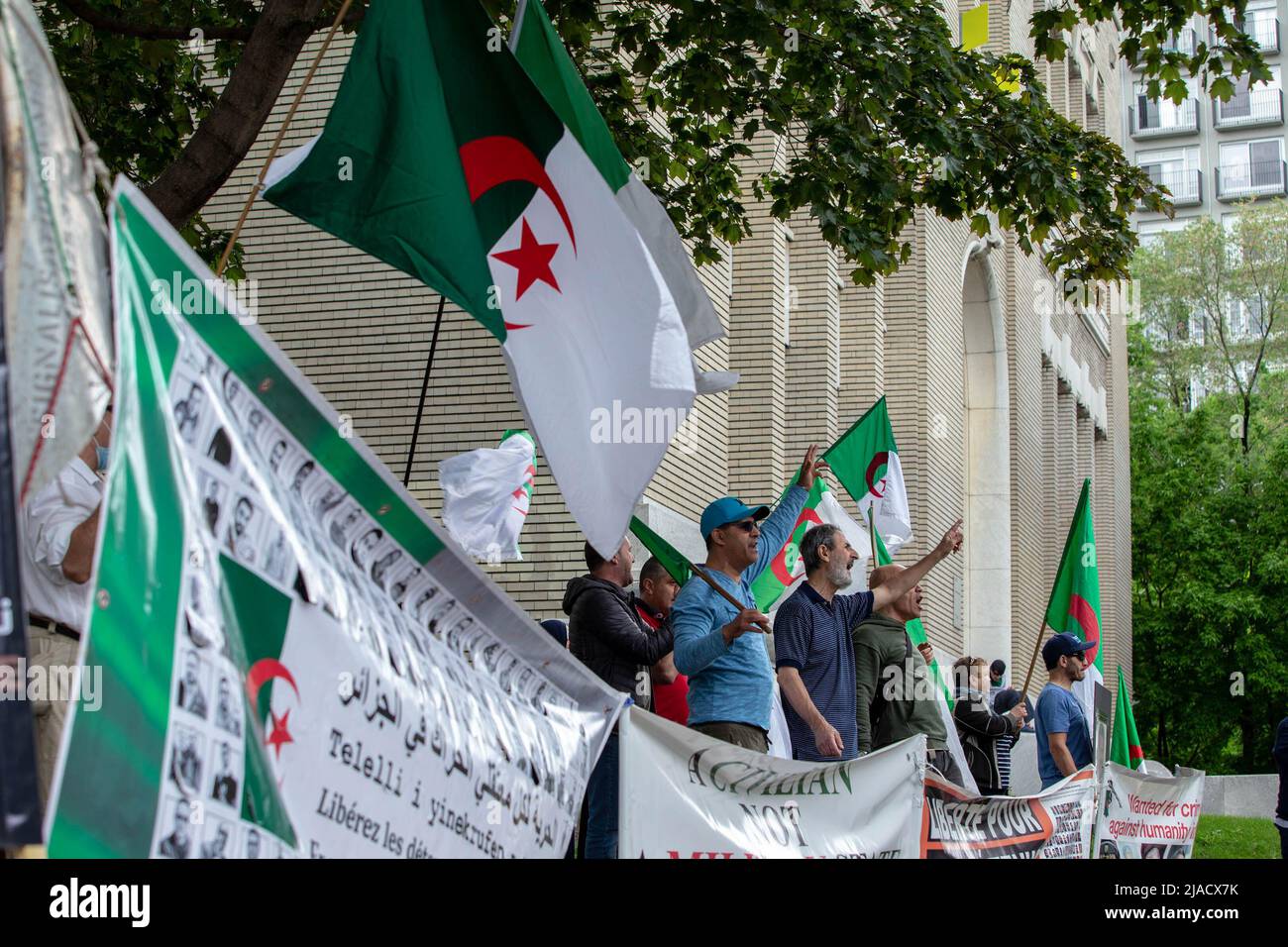 Un grupo de manifestantes Hirakim con banderas y cantos argelinos desafían a los empleados del Consulado a unirse a la protesta. Cuatro años después de la diáspora argelina, el movimiento Hirak sigue luchando por la democracia en Montreal. Organizado por Tous unis pour notre Algerie, cientos de manifestantes se reunieron frente al Consulado de Argelia para exigir la retirada de los actuales líderes políticos, encabezados por el presidente Abdelmadjid Tebboune. Citando la corrupción crónica y la falta de resoluciones previsables, los manifestantes llamaron al gobierno un gobierno mafioso. Foto de stock