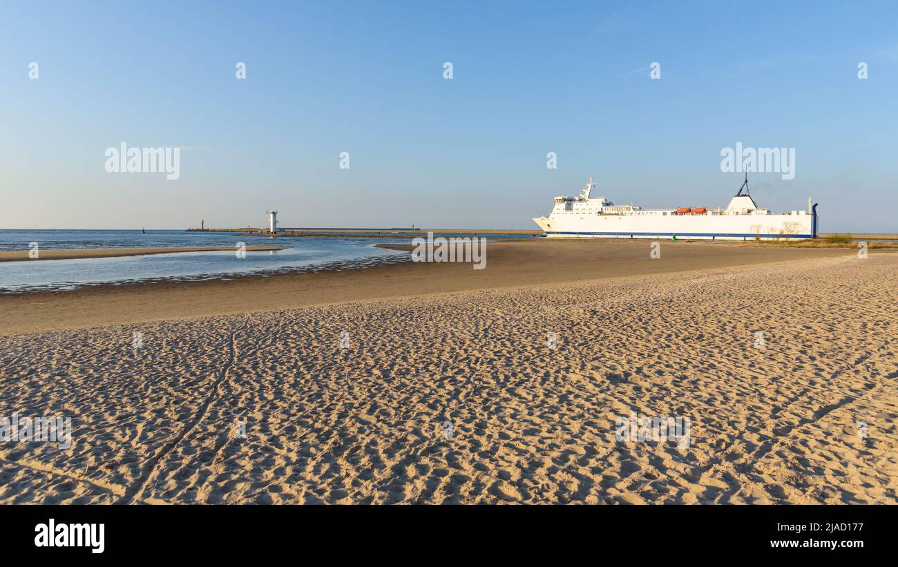Vista desde la playa de arena del gran ferry que sale del puerto de Swinoujscie Foto de stock