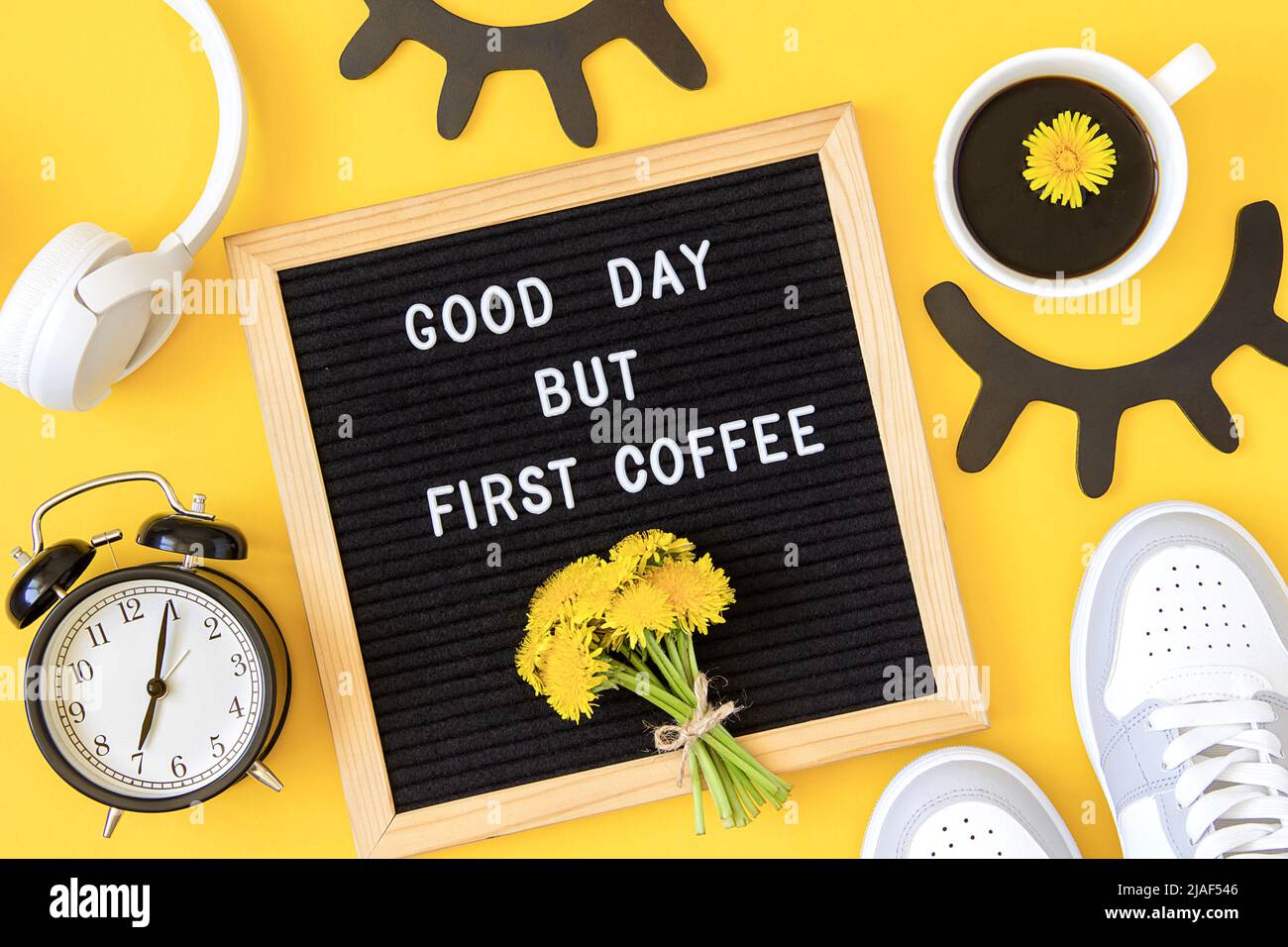 Buen día pero primer café. Cita motivacional en tablón de cartas, flores amarillas ramo y taza de café sobre fondo amarillo. Concepto inspirador qu Foto de stock