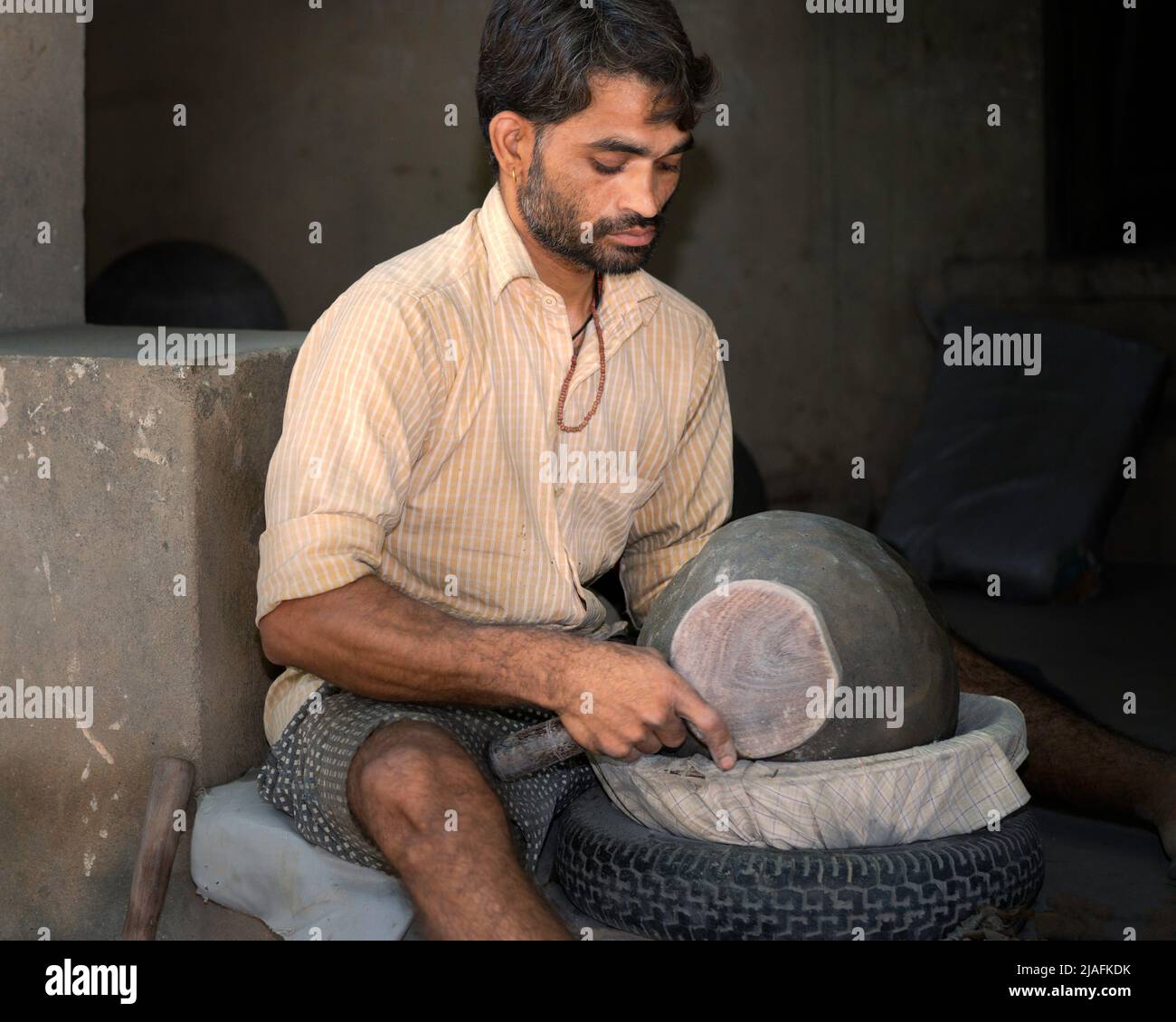 BUNDI, INDIA - 21 DE OCTUBRE de 2019: Alfarero en el trabajo que fashing un poit de arcilla usando apenas un plato de madera y arcilla casera el 21 de octubre de 2019 en Bundi, Raj Foto de stock