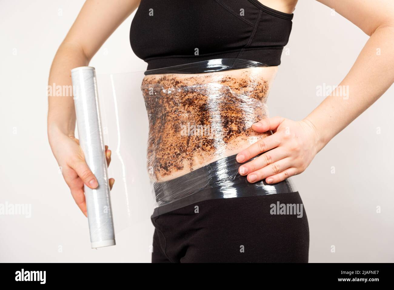 Una mujer hace una envoltura abdominal con un café anti-celulitis exfoliante  corporal. El concepto de pérdida de peso y cuidado de la piel Fotografía de  stock - Alamy