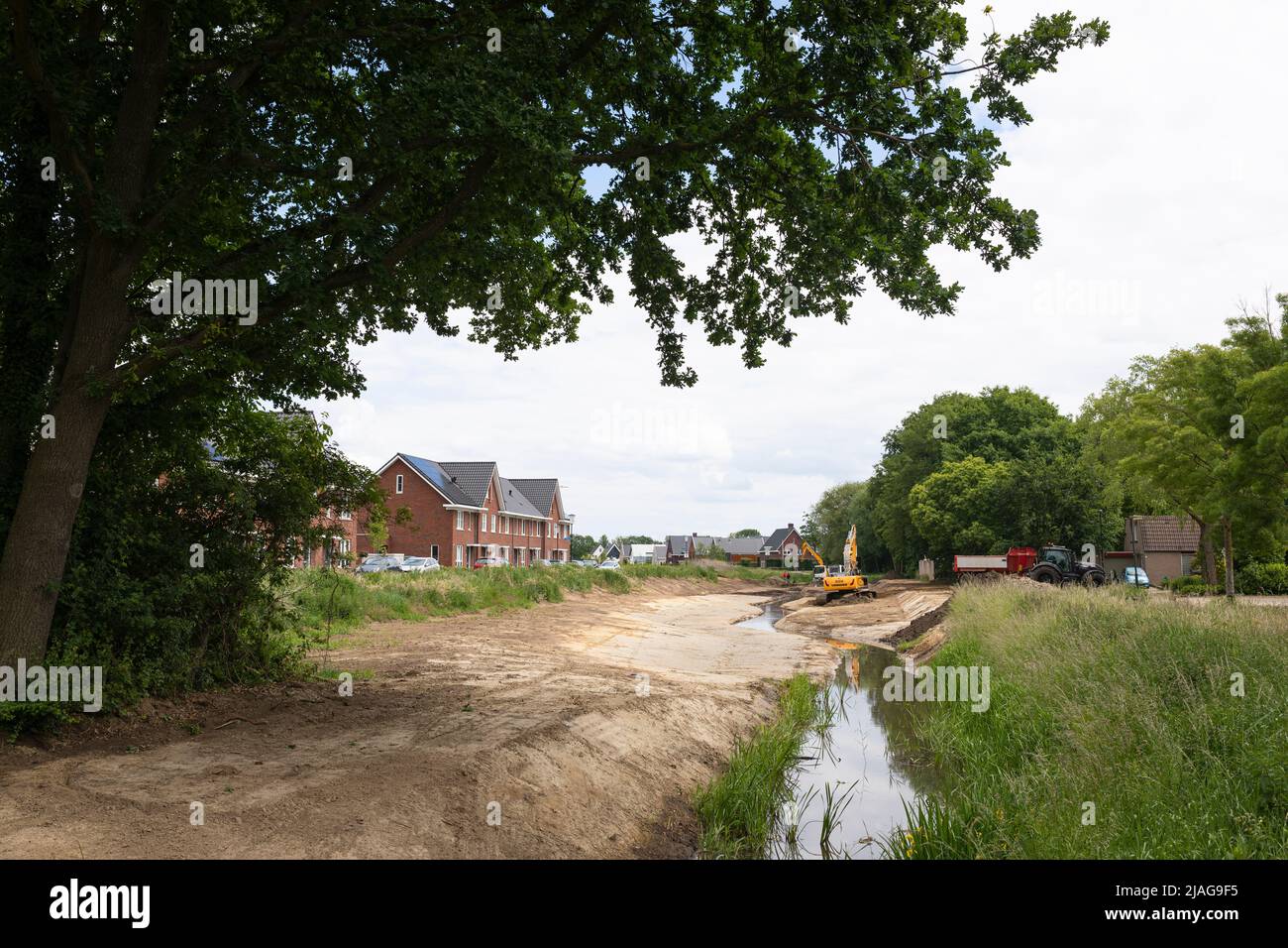Las excavadoras en funcionamiento que restauran las corrientes de agua canalizadas vuelven a su forma serpenteante en una zona residencial, la gestión del agua en los Países Bajos Foto de stock