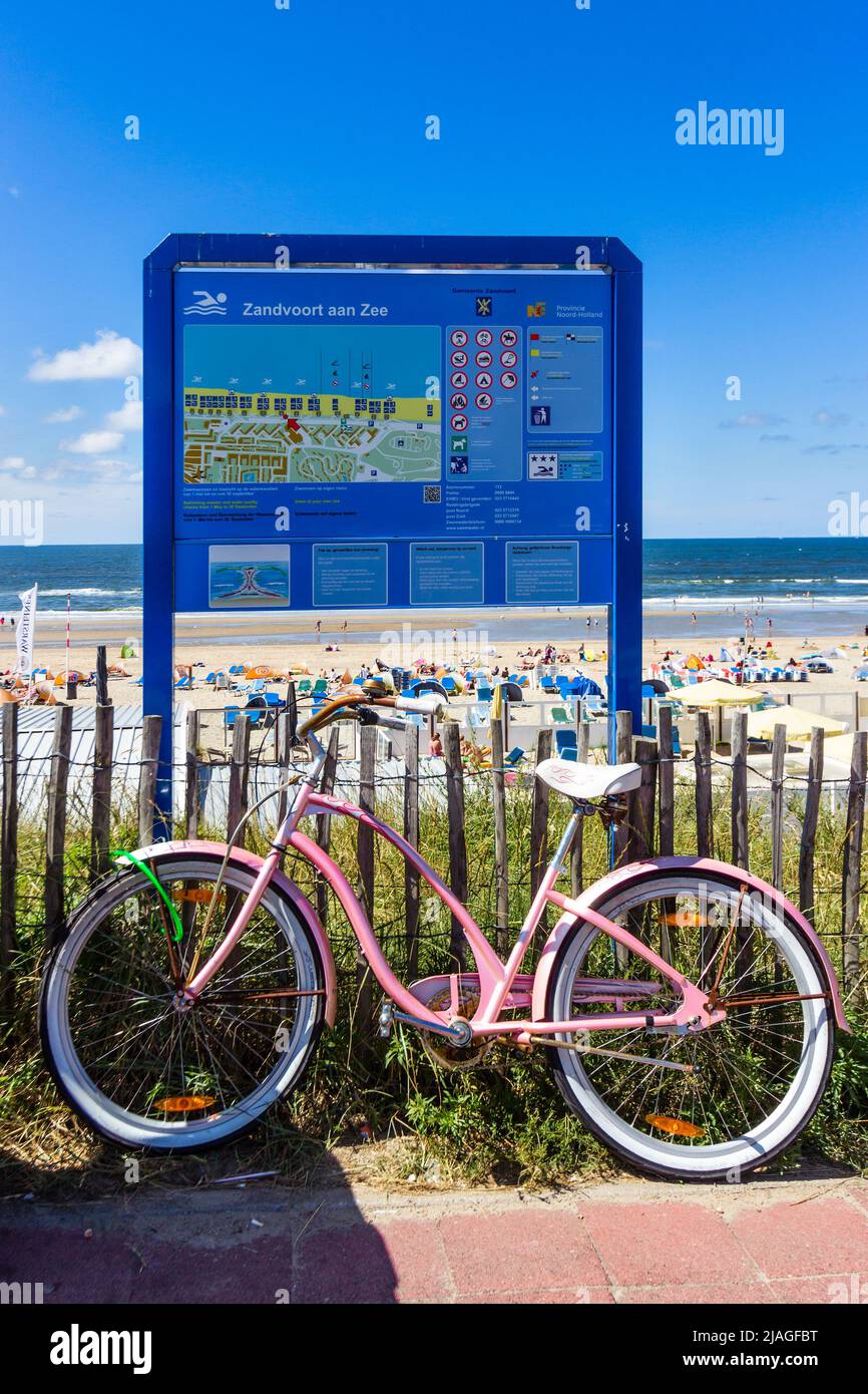 Bicicleta estacionada contra un cartel en la playa de Zandvoort aan Zee, Países Bajos - 8 de agosto de 2013 Foto de stock