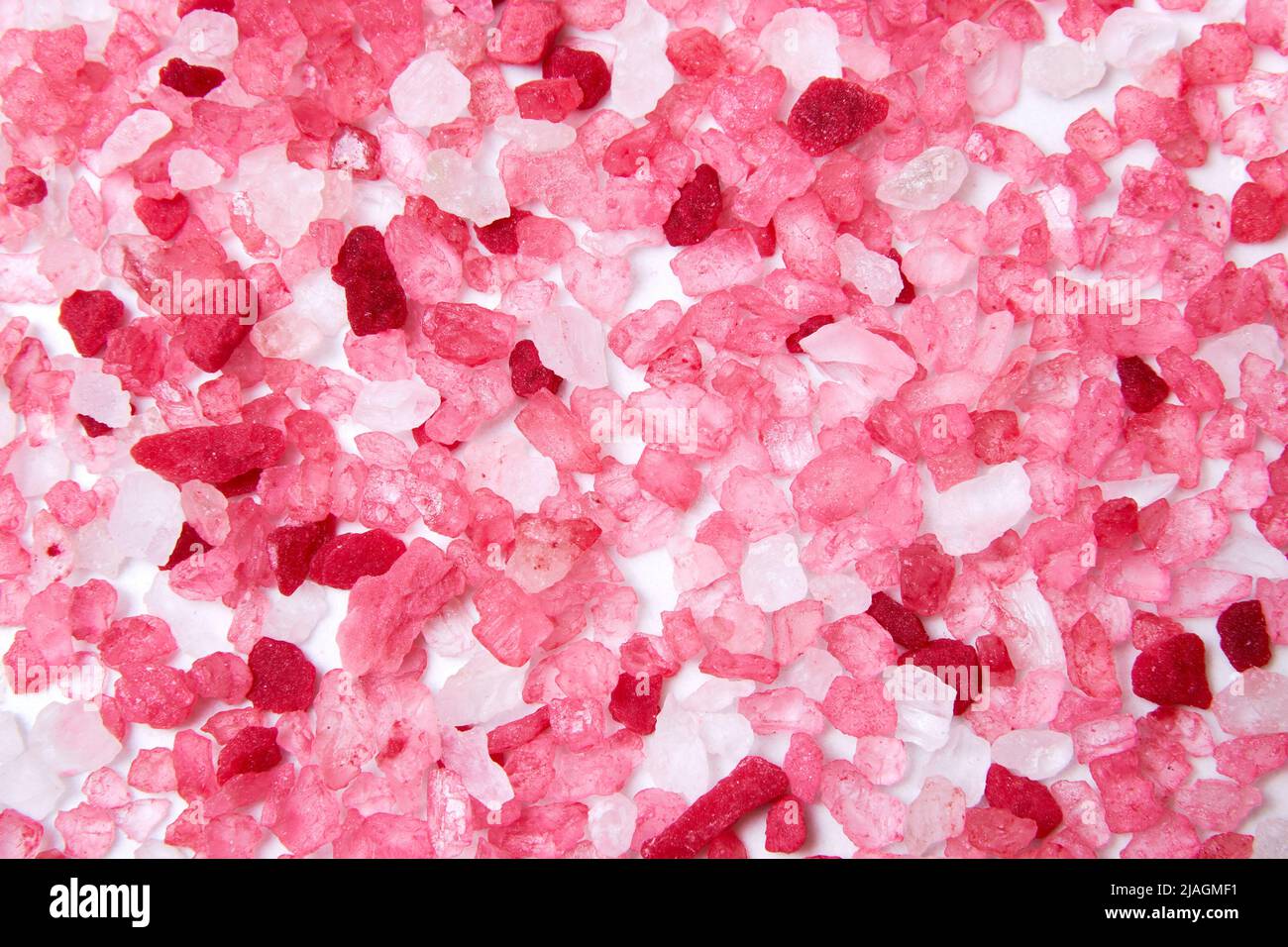 Patrón con grano de sal de baño rosa disperso en la superficie de mármol. Texturas y fondos de spa de relajación Foto de stock