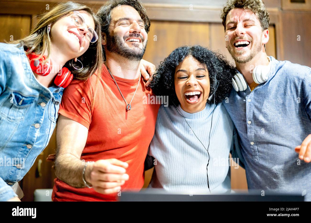Jóvenes estudiantes que se divierten riendo junto con el portátil en el estudio de inicio - Genz estilo de vida influencer concepto con amigos multiétnicos en vídeo Foto de stock