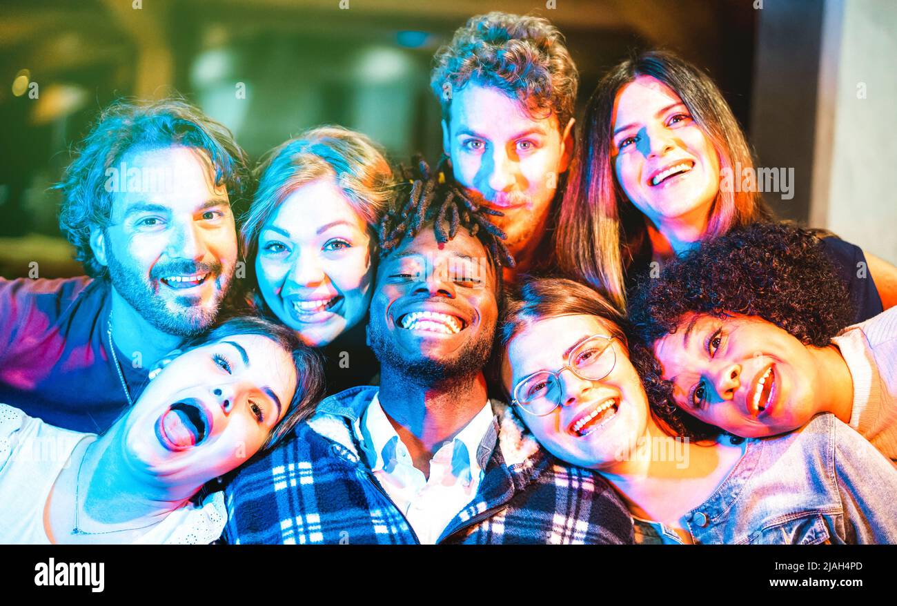 Hombres y mujeres multiculturales tomando gracioso selfie con caras felices - Social reuniendo el concepto de estilo de vida con jóvenes amigos milenarios que se divierten juntos Foto de stock