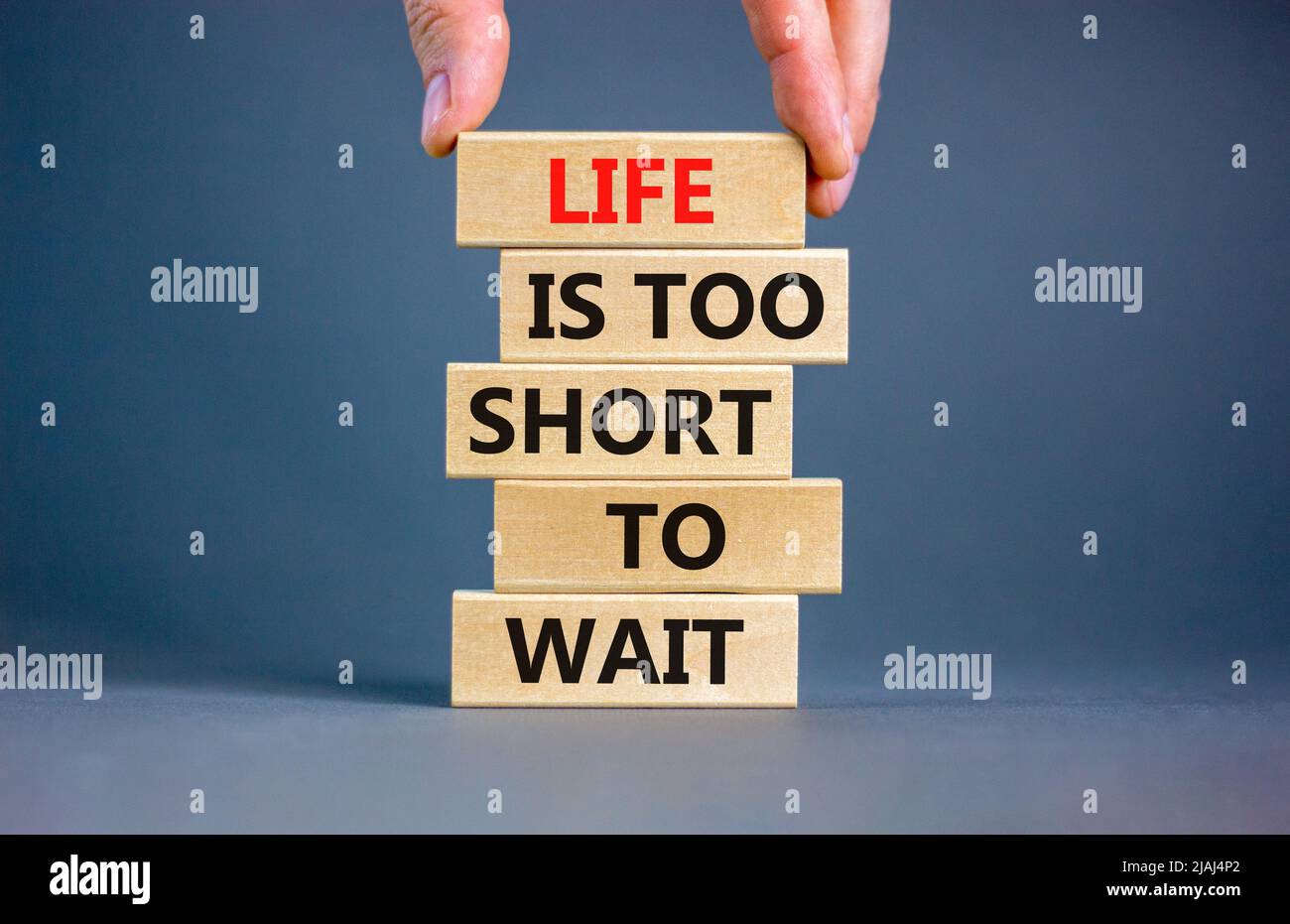 La vida es el símbolo de corto tiempo de espera. Concepto de palabras La  vida es demasiado corta para esperar en bloques de madera sobre un hermoso  fondo gris mesa. Mano de