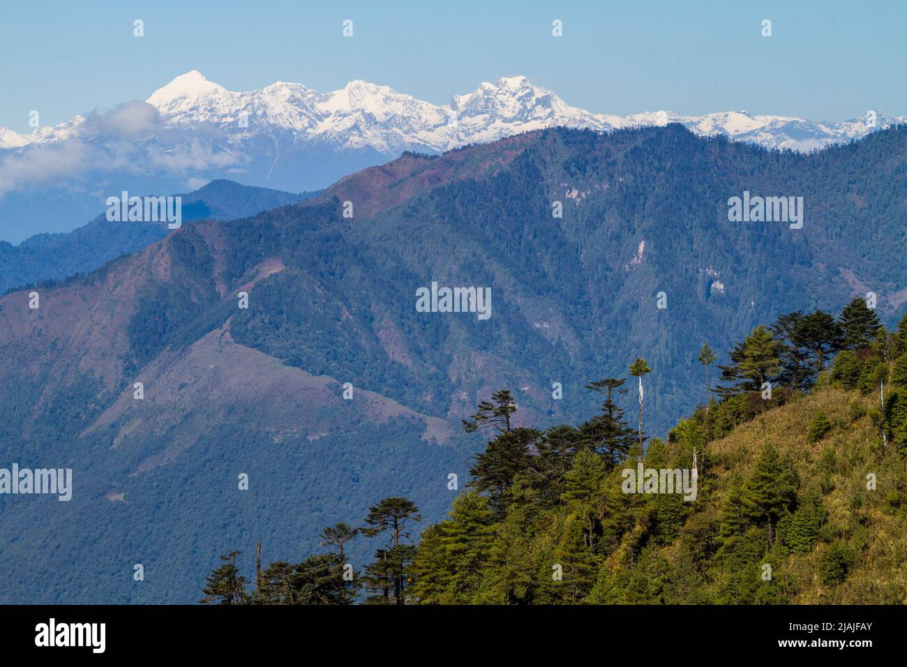 Lejanos picos del Himalaya son vistos desde la carretera en Bhután rural Foto de stock
