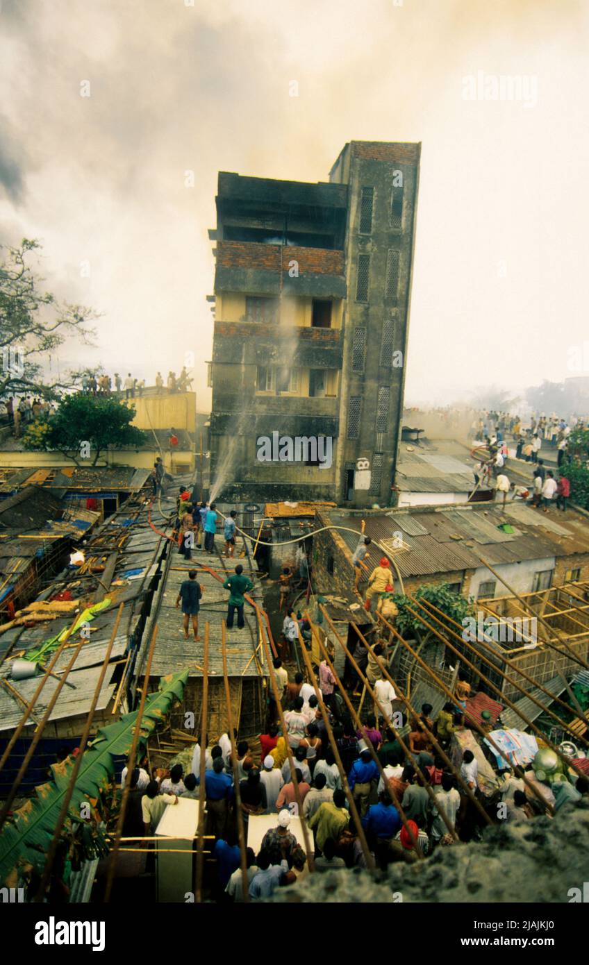 La gente trata de reducir un incendio accidental esparcido por un tugurio en Katasur, Dhaka, Bangladesh. 25 de febrero de 1998. Foto de stock