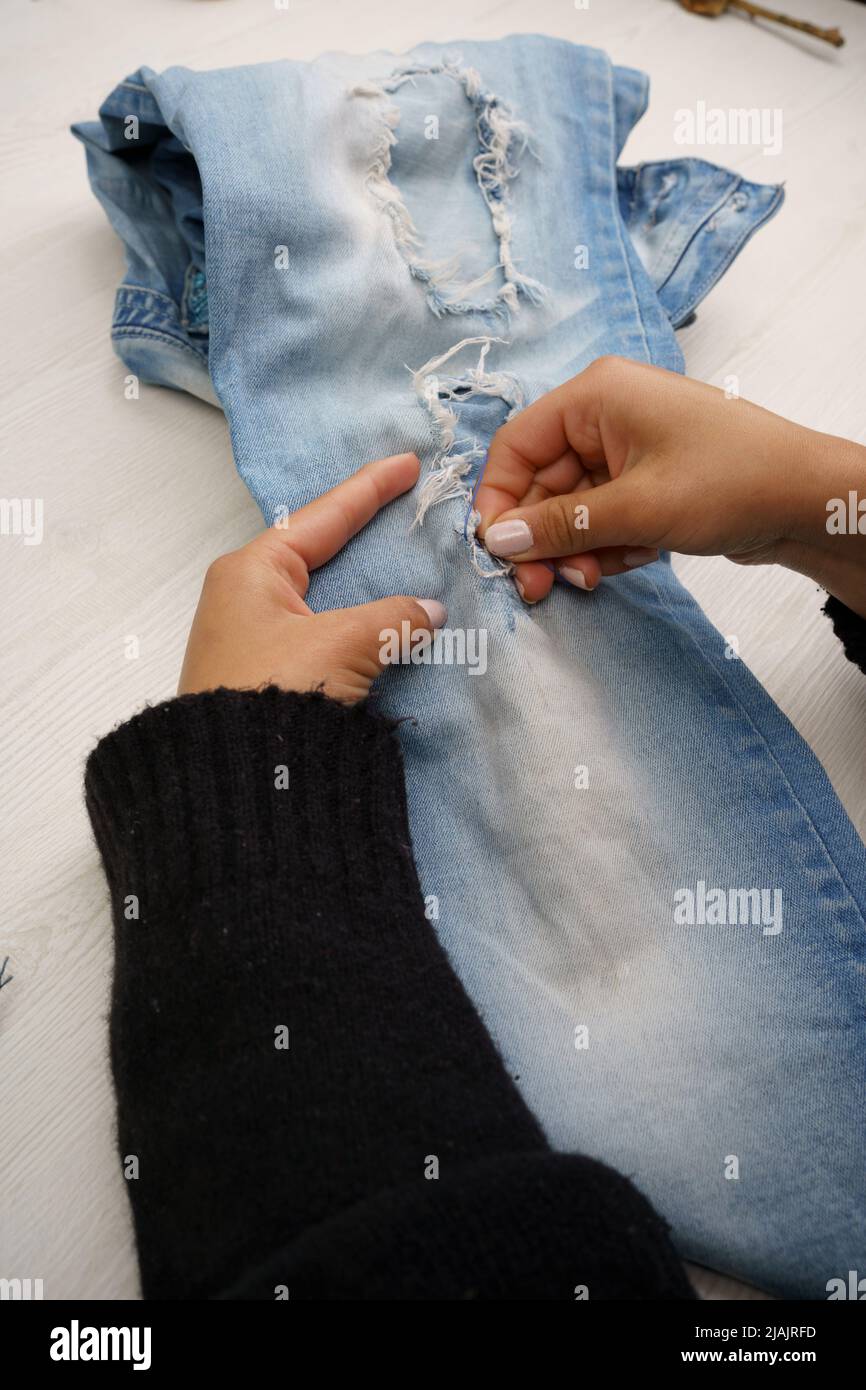 las manos coser un pantalón con aguja y hilo, el trabajo de la máquina de  vestir reparación de prendas, herramientas en el estudio Fotografía de  stock - Alamy