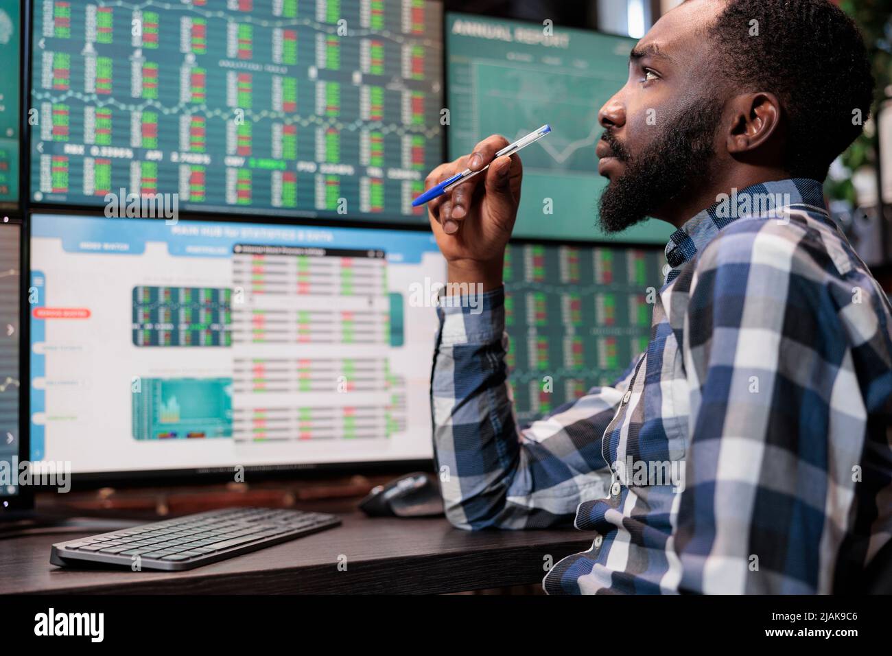 Analista financiero ocupado sentado en la estación de trabajo mientras  revisa los datos de los fondos de inversión y las estadísticas en tiempo  real. Atento comerciante de la bolsa de divisas teniendo