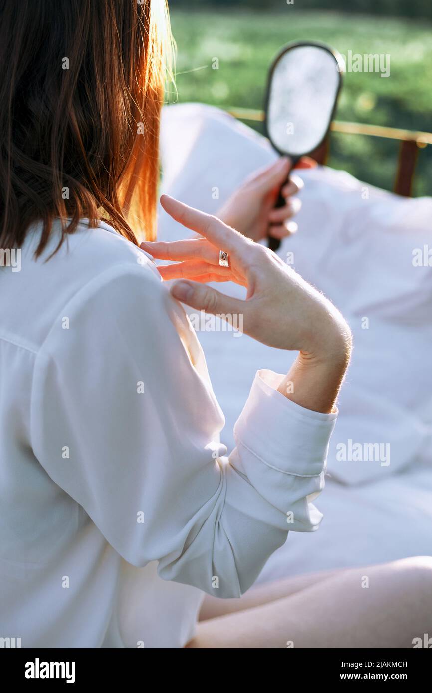una chica sostiene un espejo en su mano y lo mira Fotografía de stock -  Alamy
