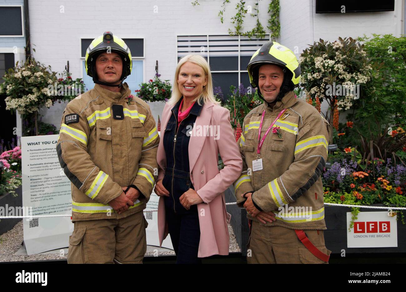 Presentadora de televisión, escritora y periodista, Anneka Rice, en el RHS Chelsea Flower Show con dos bomberos en la exhibición de bomberos. Foto de stock