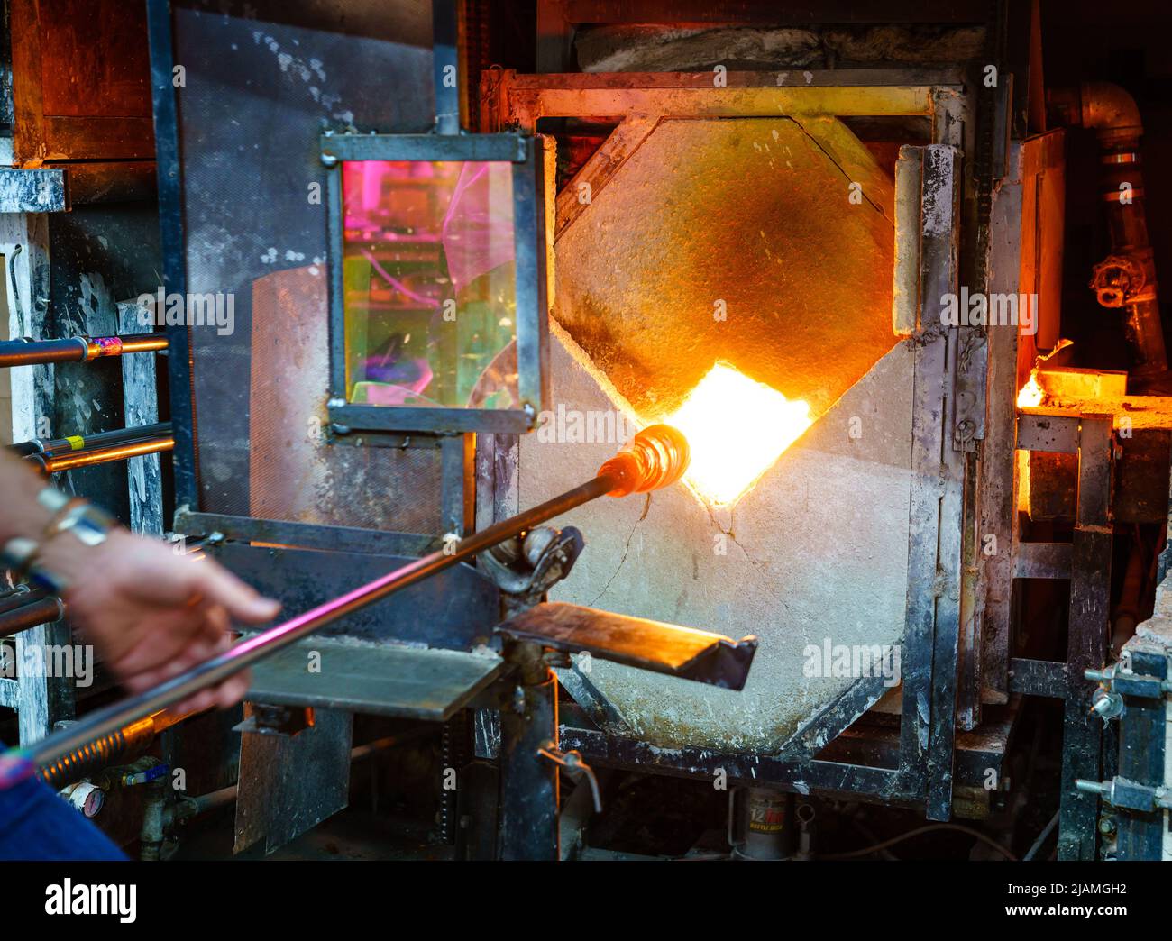 Ablandamiento del vidrio en un horno durante el proceso de soplado de vidrio Foto de stock