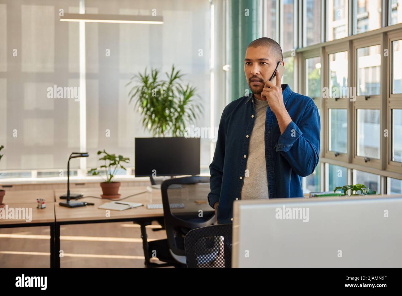 Joven hombre de negocios con confianza hablando por teléfono en una oficina Foto de stock