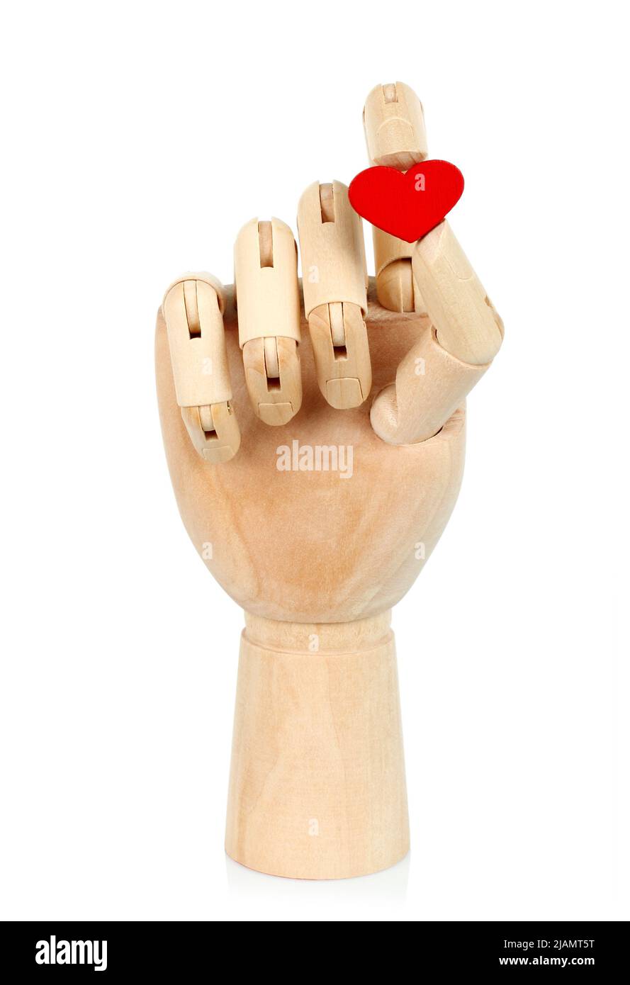 Mano de madera sostiene corazón rojo, sobre fondo blanco primer plano Foto de stock