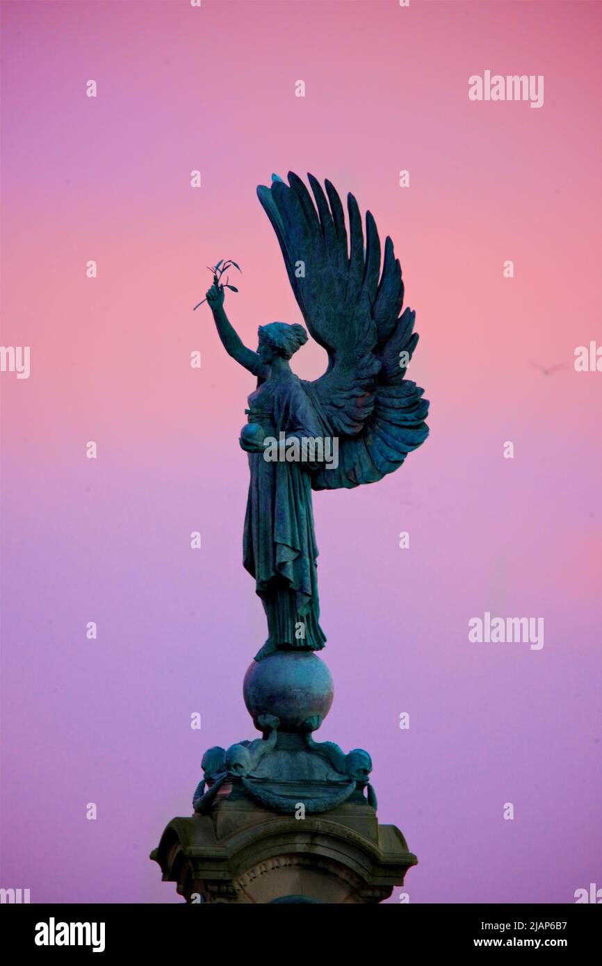 Silueta de la Estatua de la Paz de un Ángel en la frontera de Brighton Hove. Monumento erigido 1912. Brighton y Hove, Inglaterra. Rick cielo del anochecer. Foto de stock