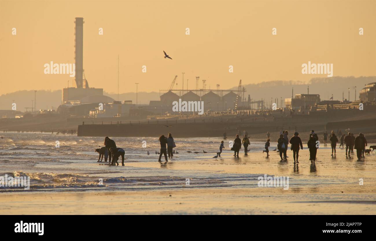 Siluetas de personas en la playa en marea baja, Brighton & Hove, East Sussex, Inglaterra, Reino Unido. Foto de stock