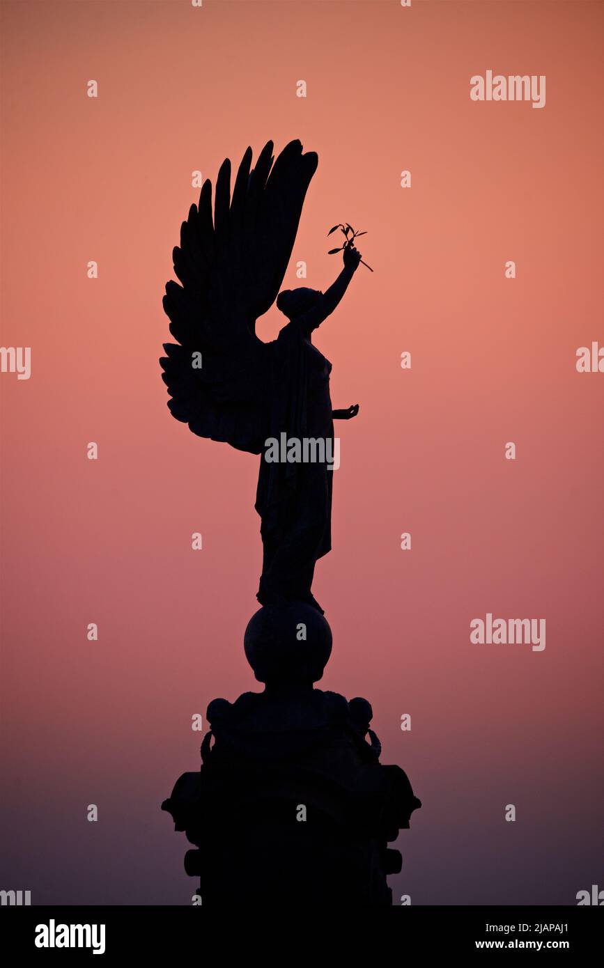 Silueta de la Estatua de la Paz de un Ángel en la frontera de Brighton Hove. Monumento erigido 1912. Brighton y Hove, Inglaterra. Rico cielo rosa oscuro al atardecer. Foto de stock