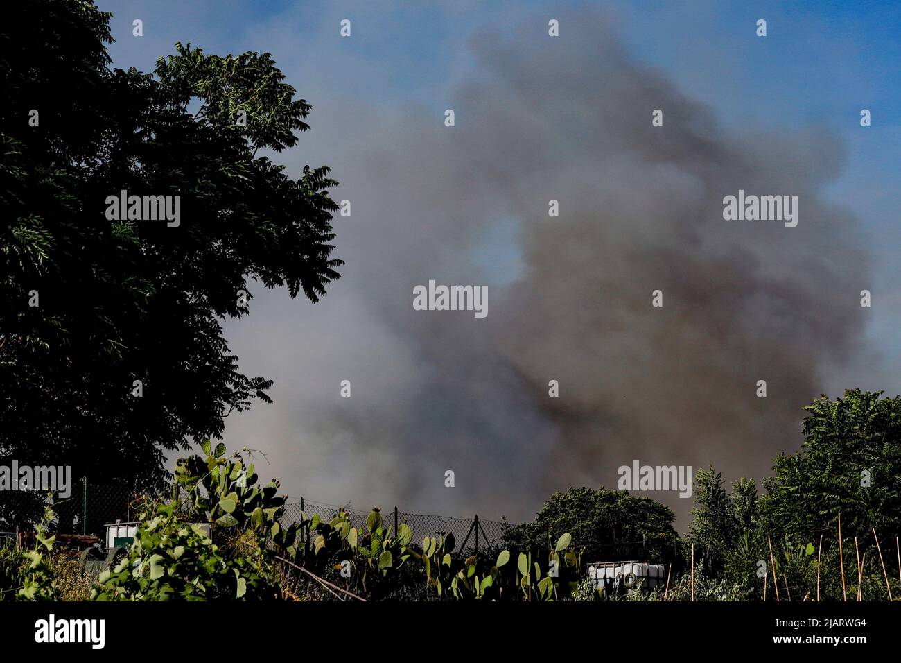 Un vasto incendium oggi pomeriggio ha interessato un area verde di proprietà della TAV in zona Prenestino. Oltre a bruciare le sterpaglie sono finiti en fumo molti materiali di risulta Foto de stock