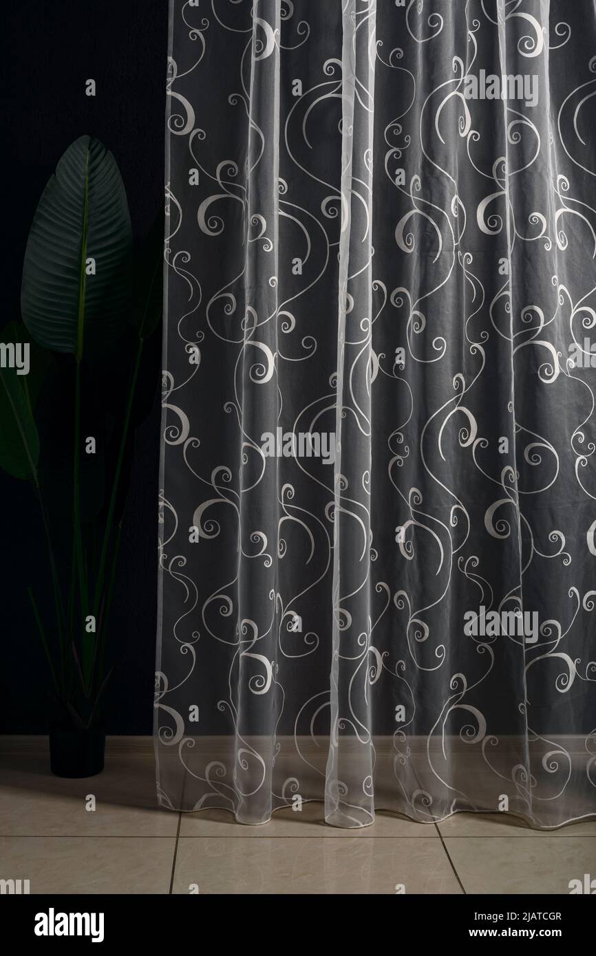 Hermoso tulle o cortina transparente con un patrón sobre un fondo oscuro.  Concepto de diseño interior Fotografía de stock - Alamy
