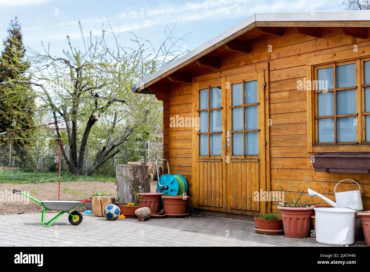 Pequeño y hermoso cobertizo de madera o cabaña de almacenamiento para  herramientas de jardín y bicicletas en el patio trasero en el hermoso campo  americano o europeo bac Fotografía de stock -