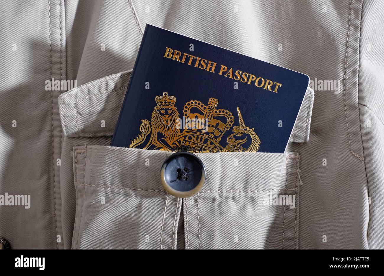 nuevo pasaporte británico en el bolsillo de la chaqueta de safari en crema Foto de stock