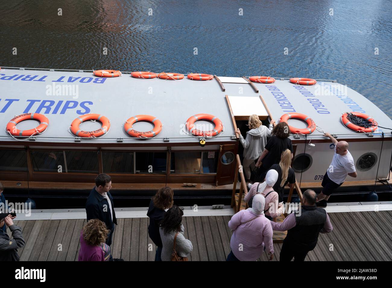 Liverpool, Inglaterra, Reino Unido. Los visitantes esperan a bordo de un barco para hacer un viaje por el río Mersey. Foto de stock