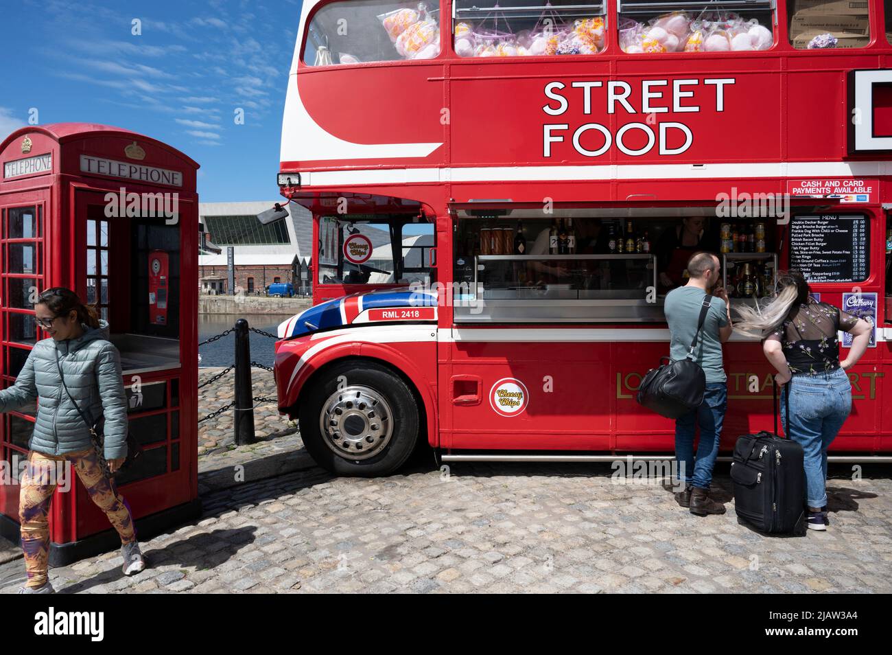 Liverpool, Inglaterra, Reino Unido. Autobús de dos pisos que vende comida callejera al lado de una caja de teléfono roja. Foto de stock