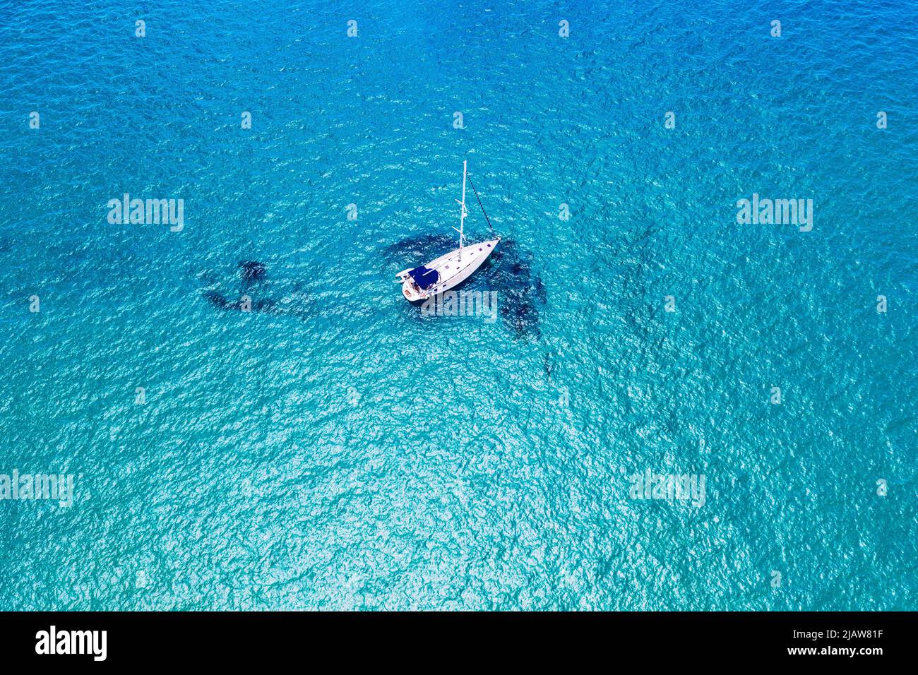 Vista aérea de un velero anclado en el mar esmeralda. Vista aérea de un barco. Deportes acuáticos al aire libre, vela. Vista aérea de anclar yate en wa abierta Foto de stock