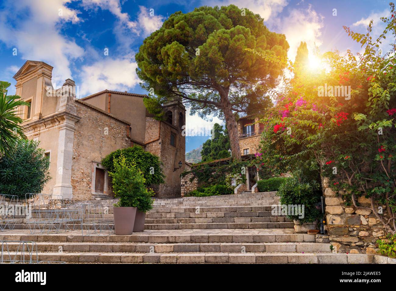 Hermoso casco antiguo de Taormina con pequeñas calles, flores. Arquitectura con arcos y antiguo pavimento en Taormina. Calle estrecha y colorida en el casco antiguo de la ciudad o Foto de stock