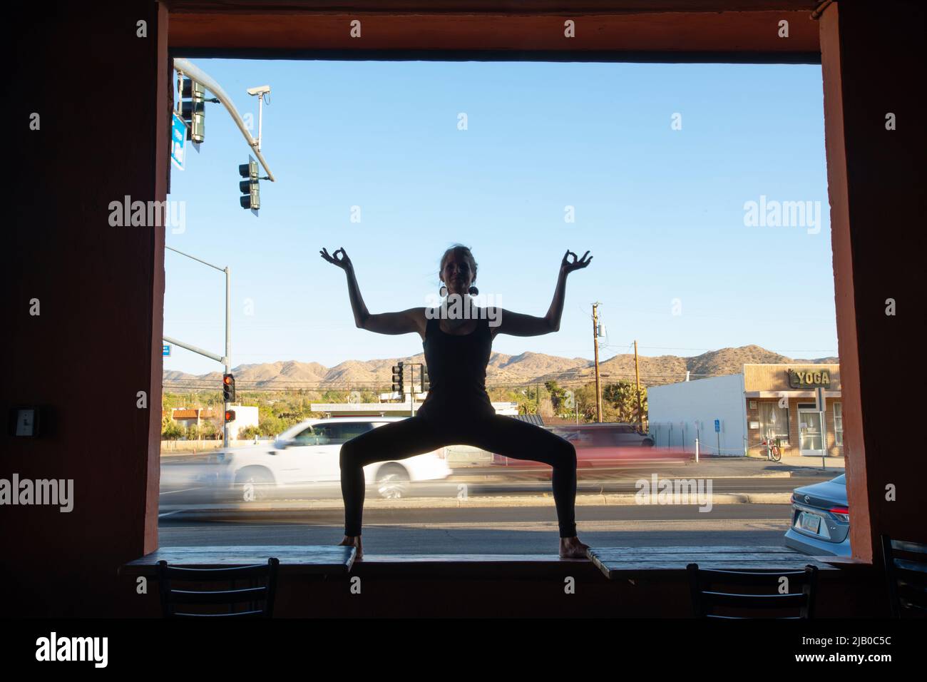 Diosa pose junto a la carretera. Yoga en un pequeño pueblo desértico en California. Foto de stock