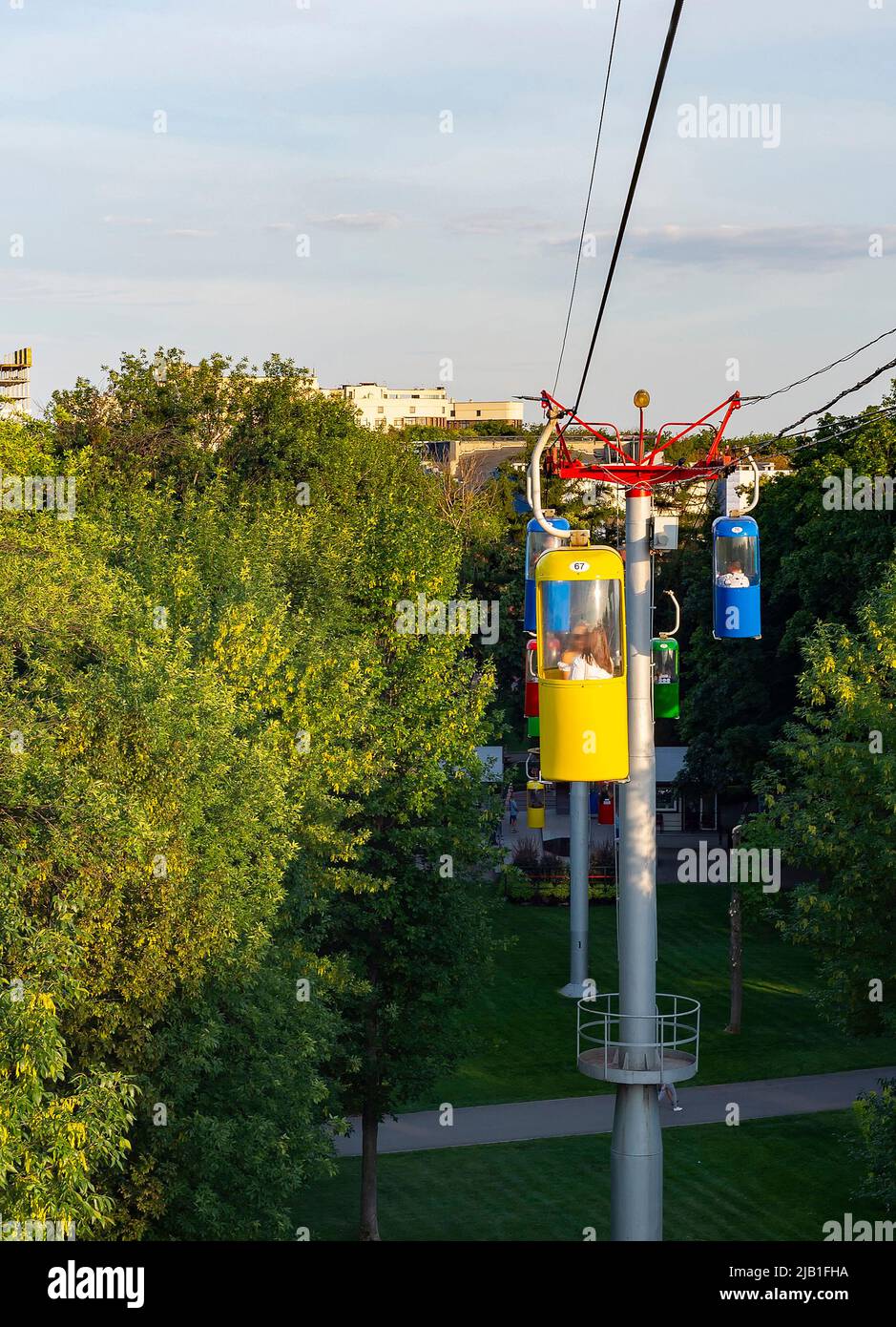 Luz del atardecer, cable sobre árboles verdes del parque, Kharkiv citycsape en el fondo, Ucrania Foto de stock