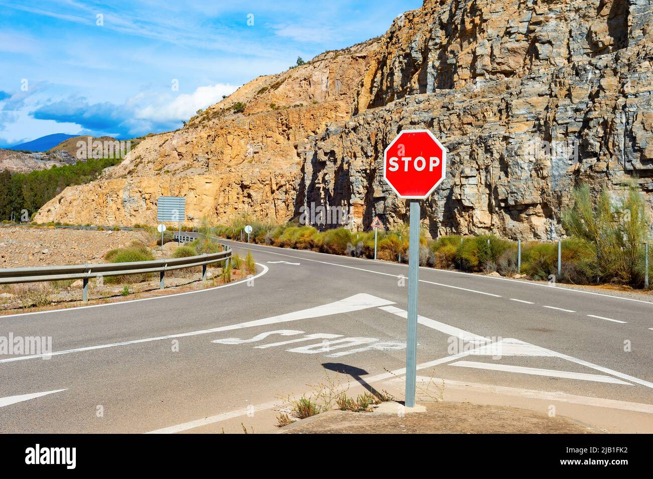 Señal de parada en carretera de montaña, paisaje soleado, España Foto de stock