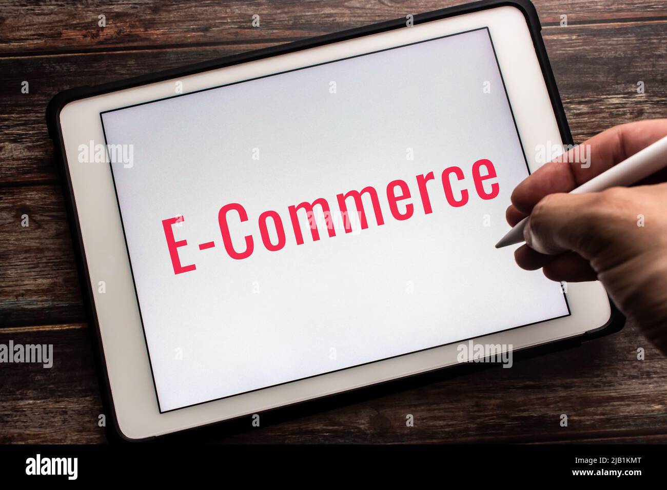 Palabra clave E-Commerce en la tableta. El comercio electrónico (comercio electrónico) es una actividad de compra/venta electrónica de productos en línea. Lápiz de mano Foto de stock
