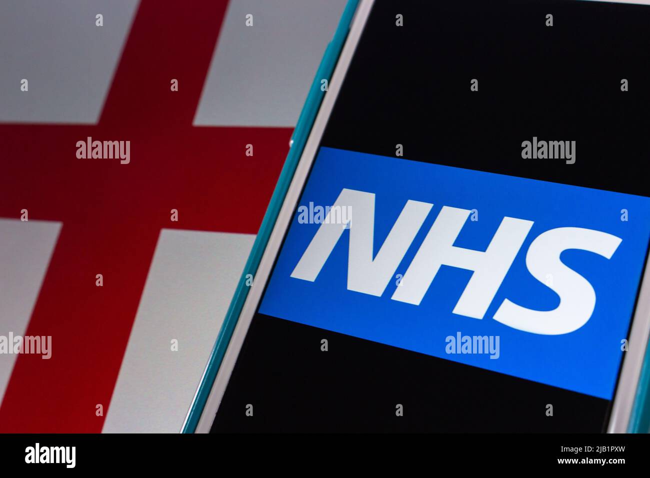 Kumamoto, JAPÓN - Sep 6 2021 : logo del NHS (Servicio Nacional de Salud) en el iPhone en la bandera de Inglaterra. Hay 3 sistemas que utilizan el mismo nombre NHS Foto de stock