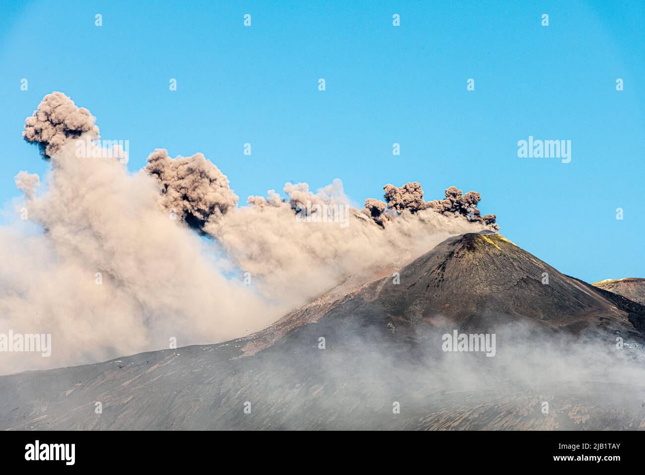 Enormes nubes de ceniza volcánica que brotan desde el cráter sudeste del Monte Etna, Sicilia, Italia. Una nueva fisura se abrió en este cráter a principios de mayo de 2022 y ha estado continuamente activa desde entonces. El Etna (3357m) es uno de los volcanes más activos del mundo y el más alto de Europa Foto de stock