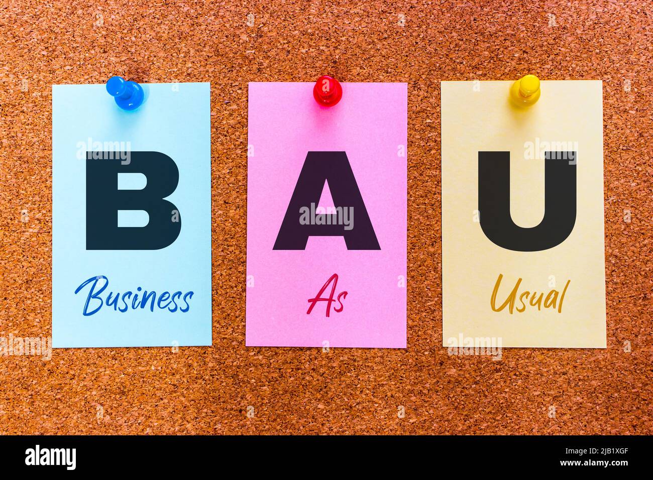 Conceptual 3 letra abreviatura BAU (Business as usual) en pegatinas multicolores adheridas a un tablero de corcho. Foto de stock