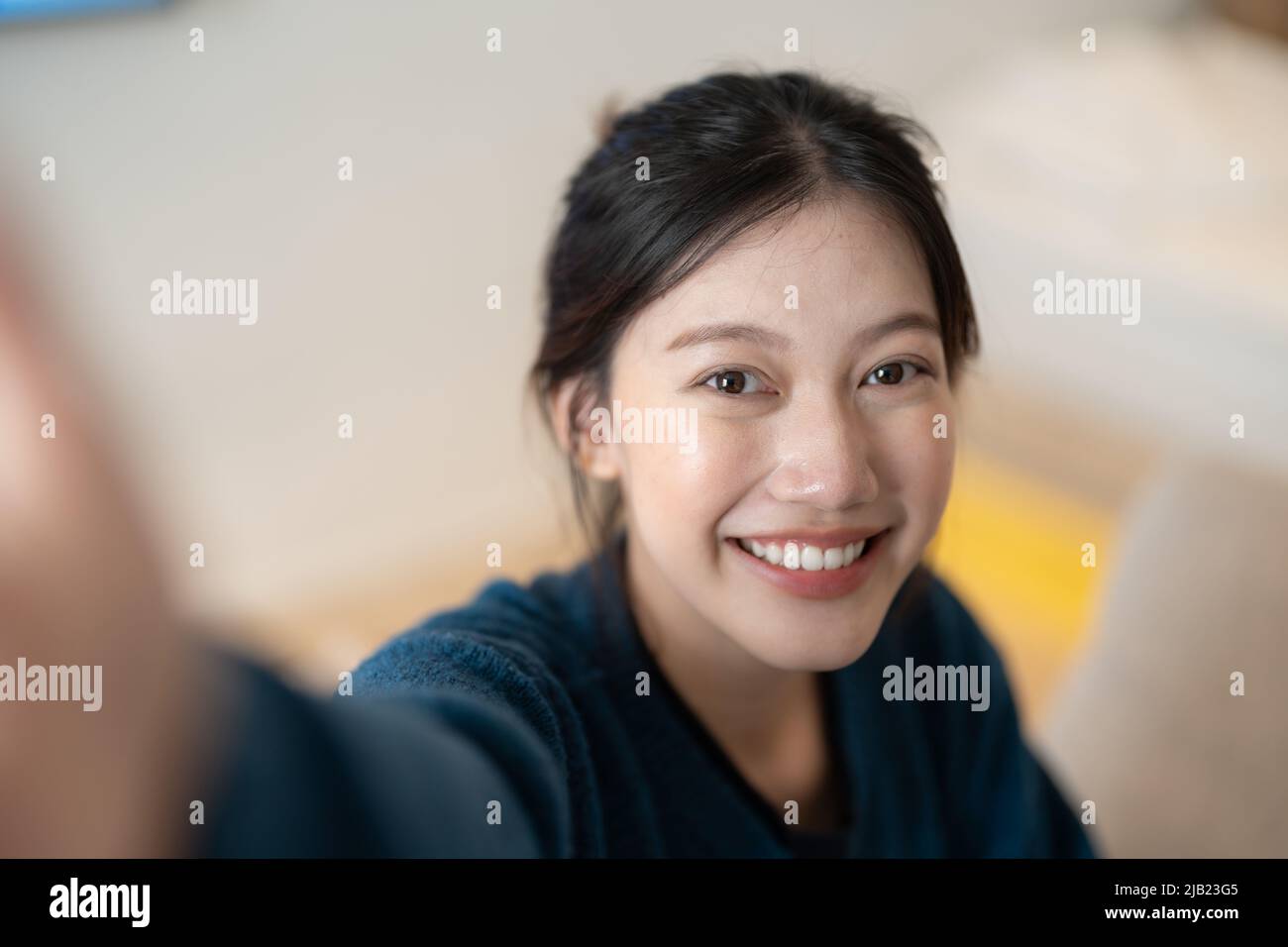 Imagen de atractiva mujer asiática joven hacer selfie con cámara en su casa Foto de stock