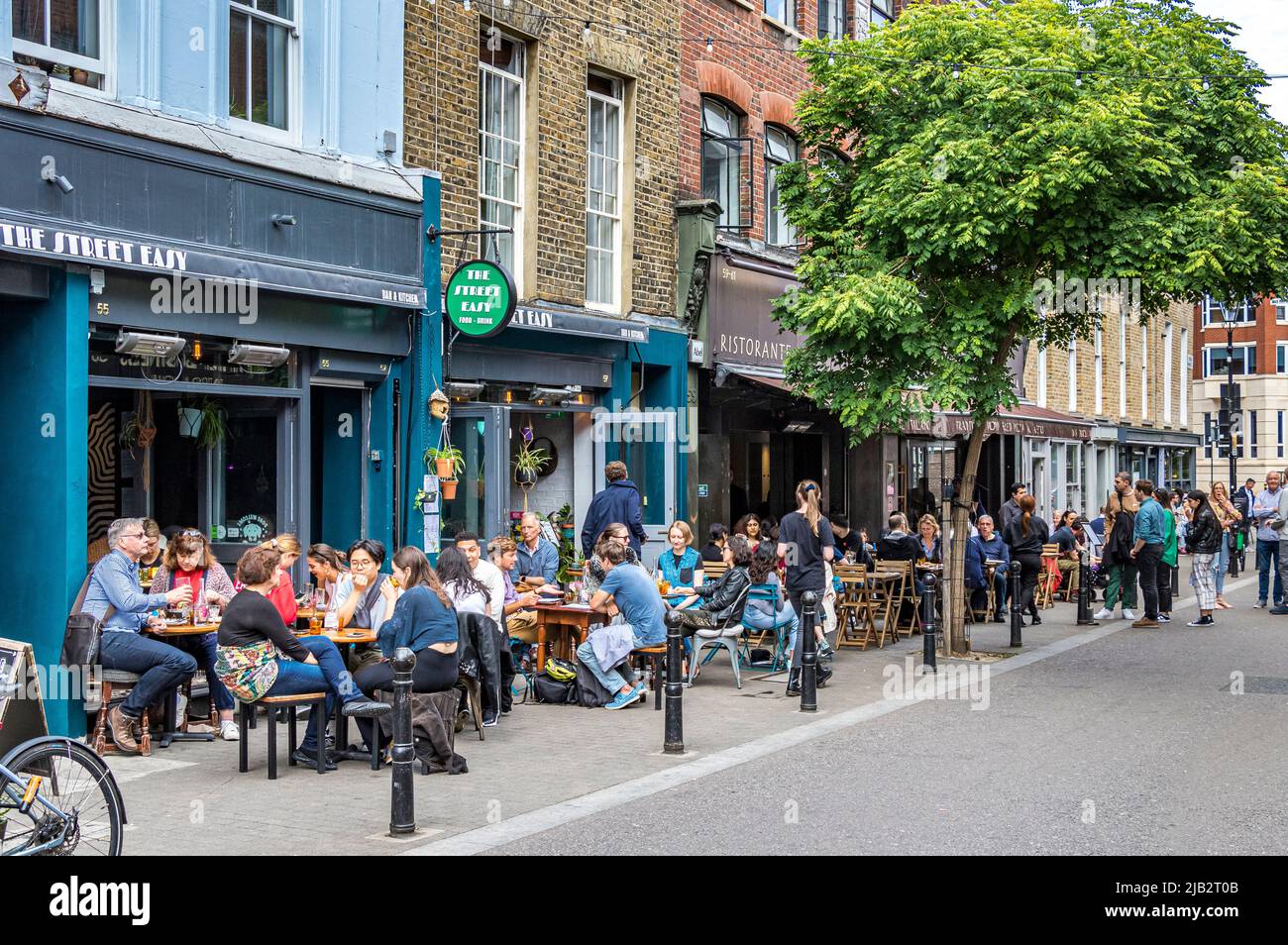 Gente sentada afuera comiendo y bebiendo en el mercado de Exmouth, Clerkenwell, Londres EC1 Foto de stock