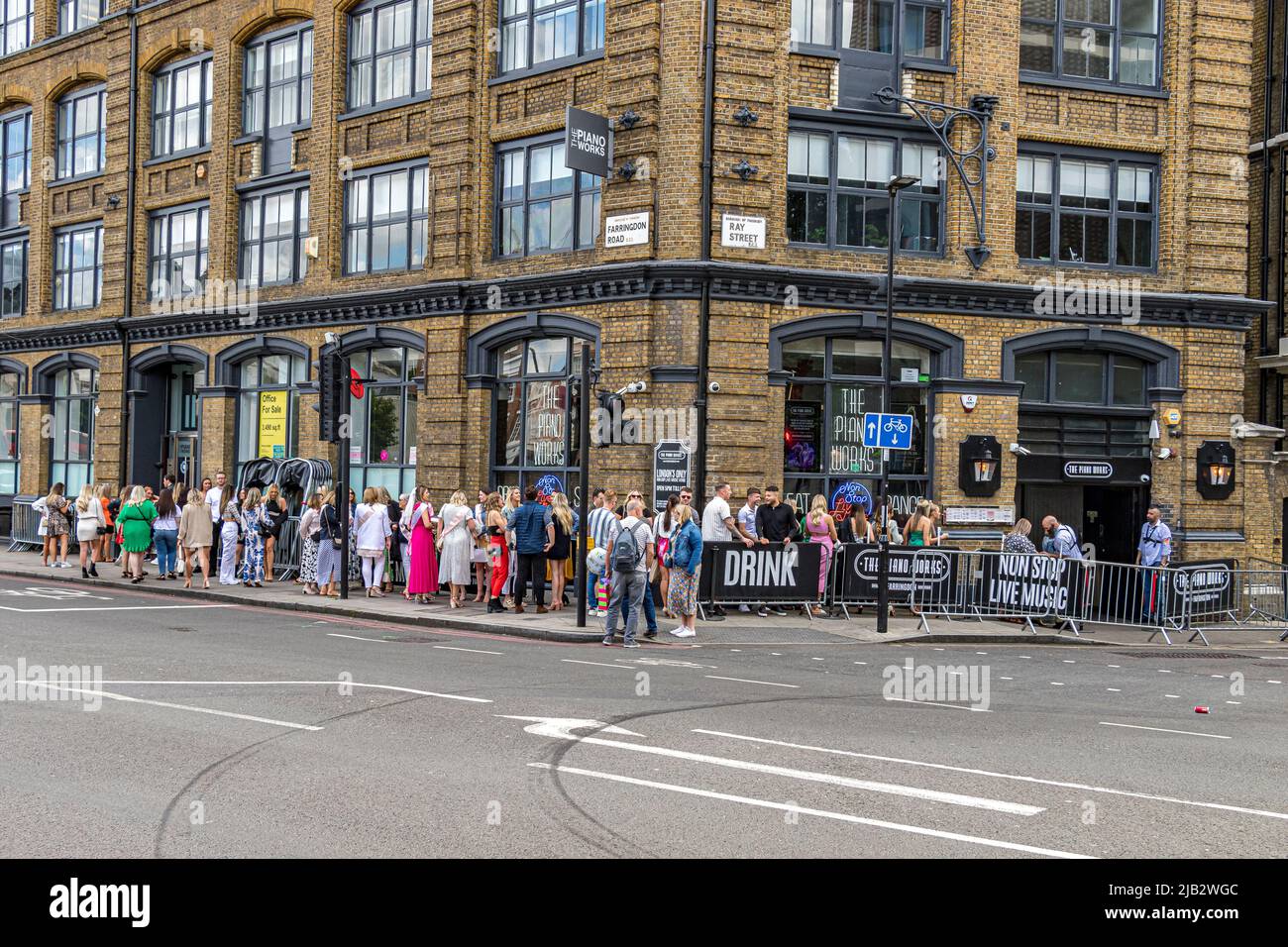 Una larga fila de personas haciendo cola fuera de Piano Works, Farringdon en Farringdon Road , Londres EC1 Foto de stock