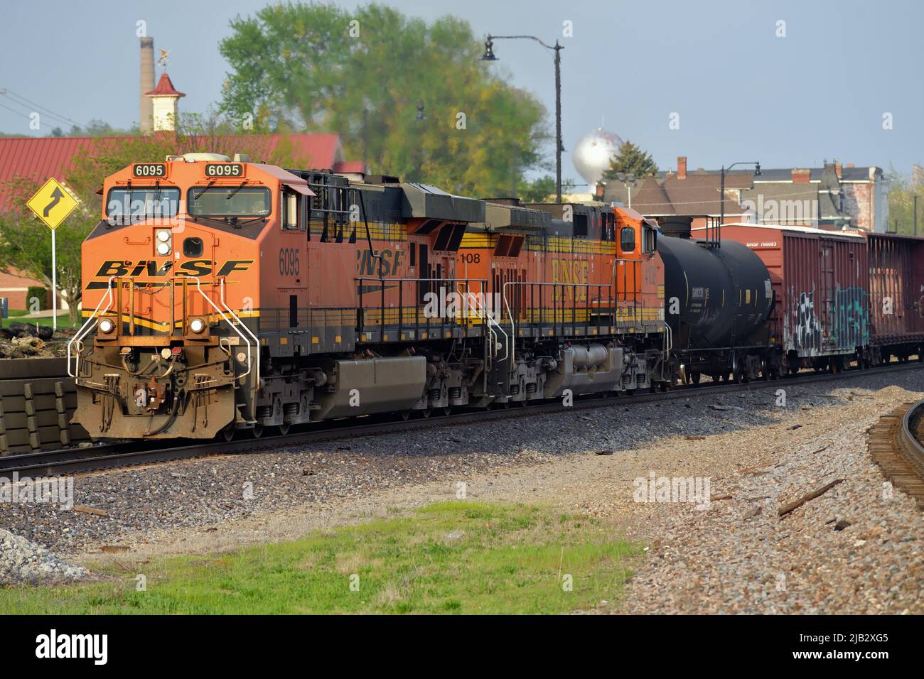 Fort Madison, Iowa, Estados Unidos. Dos locomotoras Burlington Northern Santa Fe conducen un tren de carga más allá de las plataformas de la estación Amtrak. Foto de stock