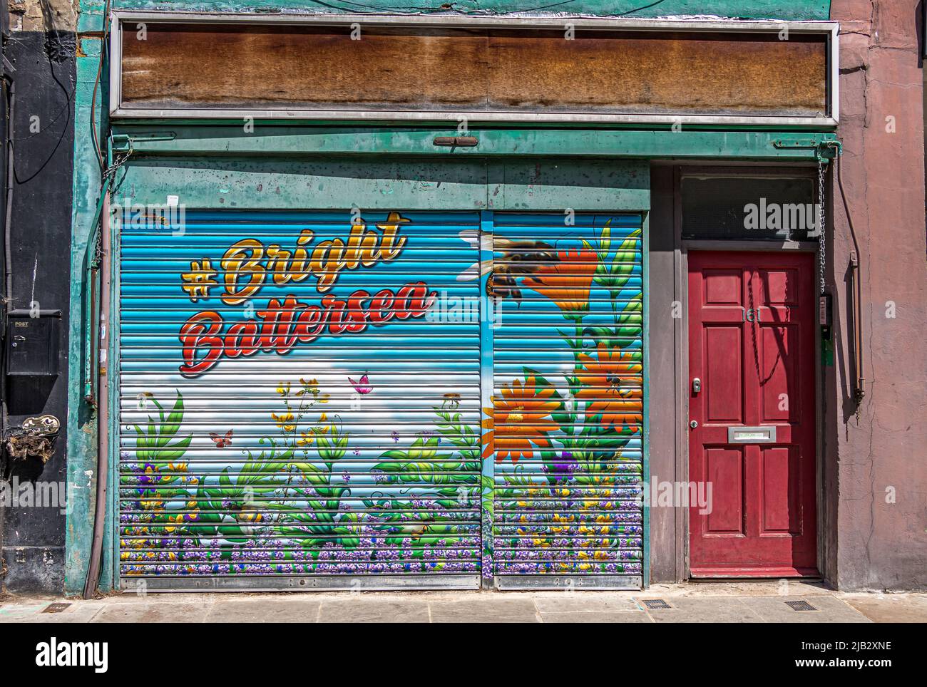 Un colorido obturador de metal pintado en una tienda en desuso, pintado con la etiqueta de hash Bright Battersea en Battersea High Street , Londres, SW11 Foto de stock