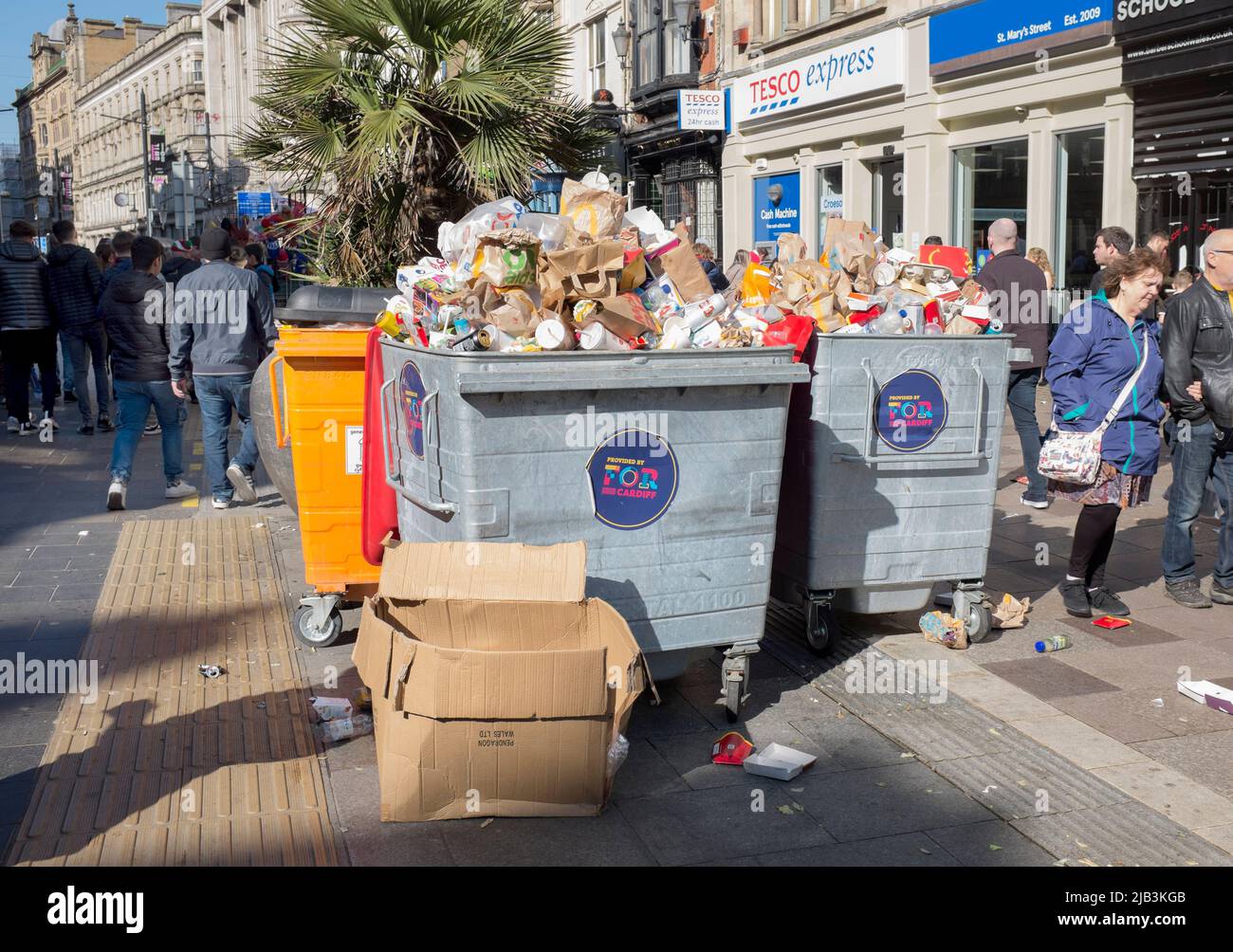 Basureros desbordados de basura en el día de partido internacional de rugby en St Mary Street, en Cardiff, Gales del Sur Foto de stock