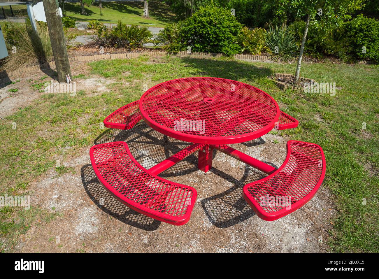 Mesa de picnic roja en un pequeño parque público en el centro norte de Florida. Foto de stock