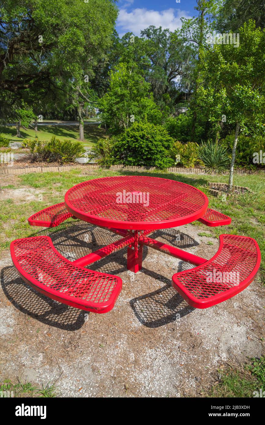Mesa de picnic roja en un pequeño parque público en el centro norte de Florida. Foto de stock